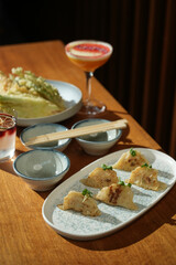 Japanese food menu, Fried Dumplings with tempura shrimps and cocktails on a wooden table