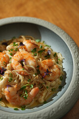 Seafood pasta with shrimps in bowl on wooden table