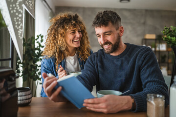 boyfriend and girlfriend read book together on breakfast at home