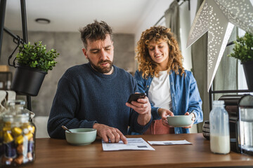 man is having breakfast and scan QR code from invoice to make payment