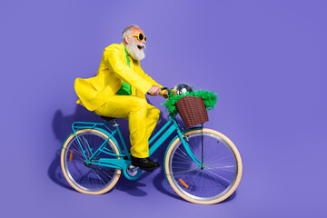 Photo of positive funny old man dressed stylish clothes traveling bicycle looking empty space...