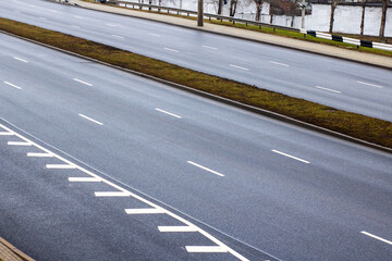 A wide, empty highway featuring distinct white lines marking it clearly