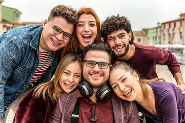 Multi ethnic twins guys and girls taking selfie picture outdoors - Millennial people having fun on...
