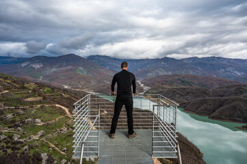 45 yo sporty tourist standing on a panoramic looking platform at the Gamti mountains, Albania.