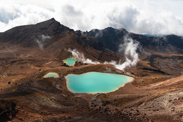 Turquoise Emeral Lakes as seen on Tongariro Crossing with emerging steam and mountain backdrop (North Island, New Zealand)