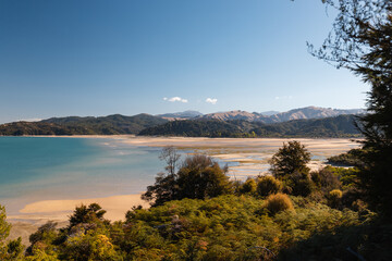View onto Otuwhero Inlet in Abel Tasman National Park during sunset and low tide on a clear summer day (South Island, New Zealand)