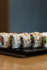 Close-up of five sushi rolls arranged on a delicate plate