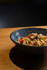 Intimate shot of a wok filled with colorful stir-fried vegetables, illuminated by warm, dramatic lightin