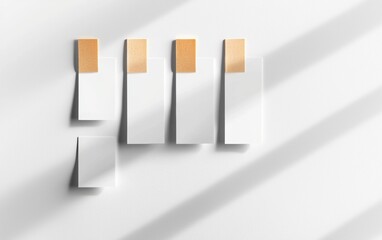 White sticky notes taped at the top with yellowed adhesive, arranged in a row with natural shadows for a casual and realistic design concept