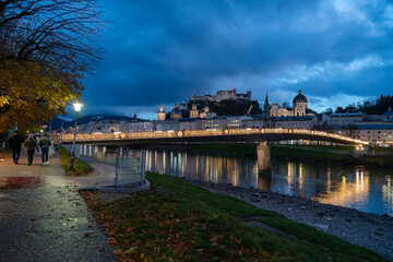 Salzburg Austria at night - love padlocks placed by couples on a fence of the Makartsteg (Makart's bridge) illuminated at night by Christmas lights along Salzach River