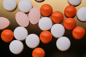 Colorful pills on a golden background.