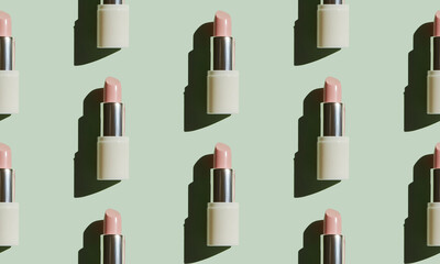 Obraz premium Repetitive seamless pattern of pastel pink lipstick tubes casting shadows on a light green background, creating a stylish and modern beauty product presentation