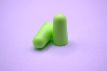 Green earplugs on a white background. Hearing protection.