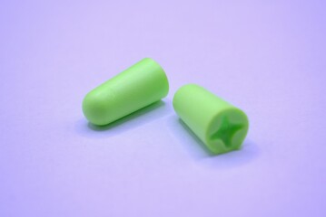 Hearing protection. A pair of green earplugs on a white background.