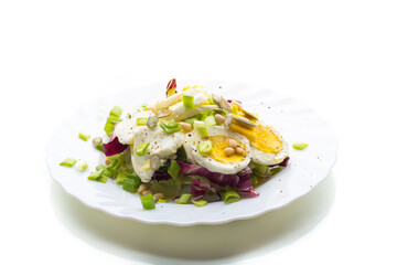 Light salad with egg in a plate, isolated on white background