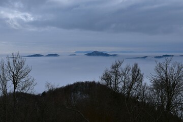 Tošc hill in Slovenia rising above the clouds