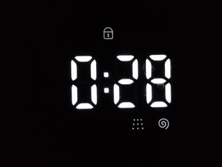 Time on the washing machine timer. Countdown while washing clothes on a black display.