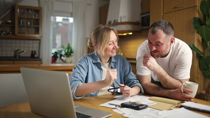 Digital finance solutions, couple handle online transactions and review financial records. Checking bills and making secure online payments using a laptop streamlines financial tasks around home.