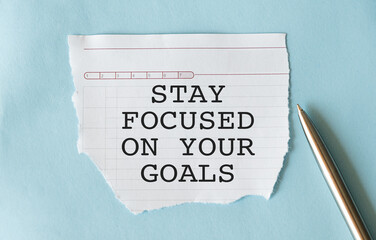 Inspirational quote - Stay focused on your goals. With text message on white paper on blue background.
