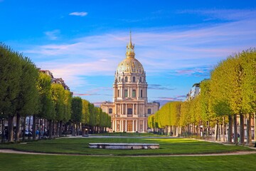 Les Invalides dome in Paris surrounded by trees and a colorful sky