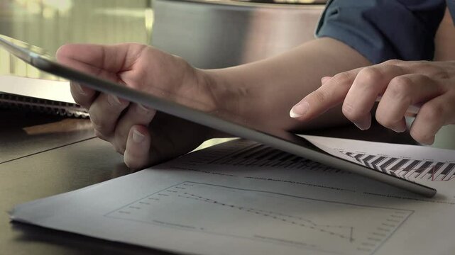 young businesswoman typing on her tablet computer sitting in a table of a cafe