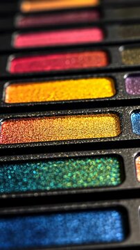 Colorful shimmer eyeshadow palette with a variety of shades arranged in uniform rows