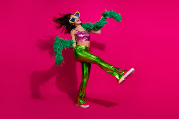 Young Woman Dancing in Vibrant Disco Outfit Against a Bright Pink Background