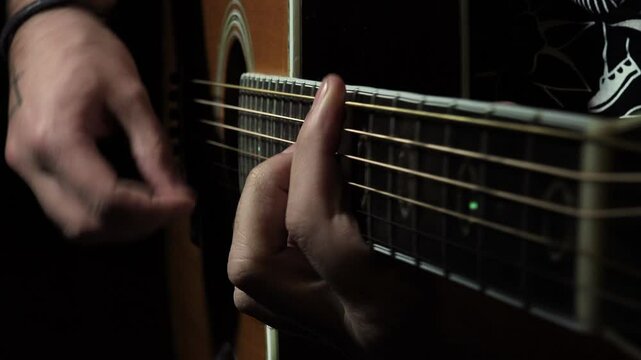 guitarist playing in the darkness inside a recording studio