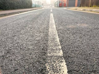 Freshly painted white road markings on a clean suburban street at sunrise.