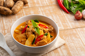 Thai red curry soup with pork and yam(Dioscorea esculenta yam),boiled sliced pork with red curry paste and coconut milk in white bowl.