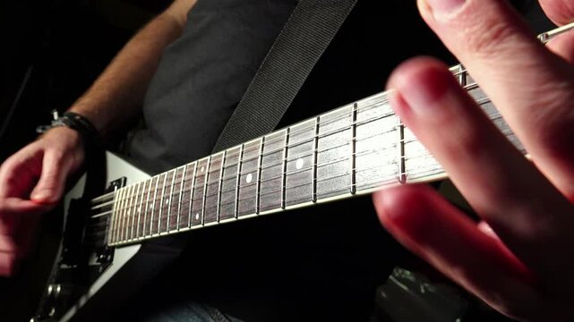 close-up shot on the hands of a rock guitarist close to the guitar handle