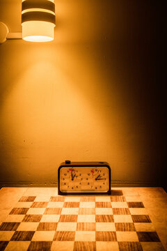 Chessboard with a clock under a warm wall light in Lapland