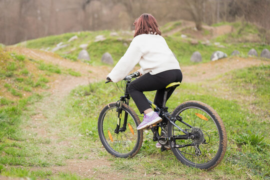 Girl Mountain Biking Through Scenic Off Road Trail