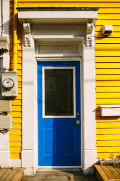 Bright blue door on a vibrant yellow house in St. John's