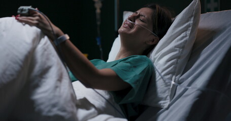Exhausted female patient in hospital ward cries because of stomachache.
