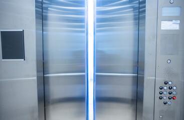 Looking from inside an elevator to the outside with the doors partially opened and a bright blue light showing through © F Armstrong Photo