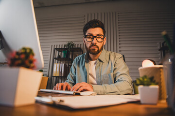 Confident professional man working in stylish office with plants and natural light