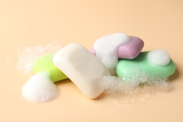 Soap bars with foam on beige background