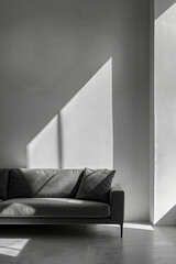 A gray couch sitting in front of a white wall