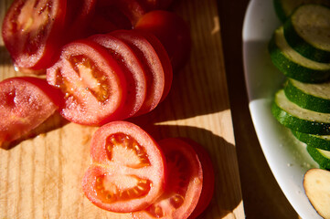 Sliced Tomatoes and Zucchini on Wooden Cutting Board in Natural Daylight