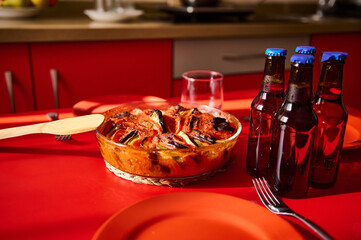 Delicious baked dish with arranged vegetables and beverages on a brightly set table