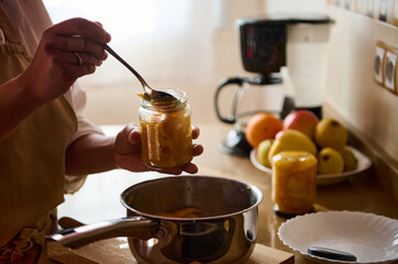 Homemade preserves being prepared in a kitchen with fresh fruits and utensils