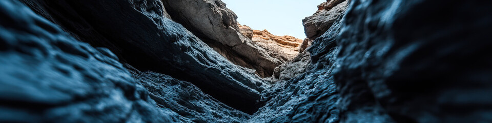 Low-Angle View of a Narrow Canyon with Dark Grey and Blue Rock Formations