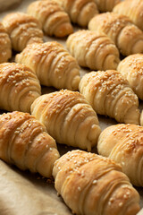 Baked crescent rolls with sesame seeds in a pan. Fresh homemade pastry.