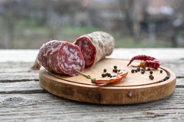 Air-dried typical  Italian salami from Tuscany served on a wooden board .  Autentic Tuscan Salami from San Gimignano, Siena 