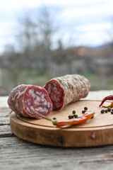 Air-dried typical  Italian salami from Tuscany served on a wooden board .  Autentic Tuscan Salami from San Gimignano, Siena 