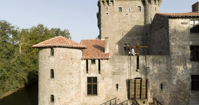 Knight climbing up majestic, ancient castles draw bridge - swooping drone shot