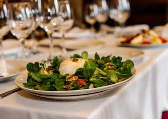 Fresh salad with burrata cheese, walnuts and lamb's lettuce served on elegan