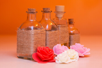 beautiful bottles with massage oil on orange background