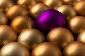 varias esferas doradas rodeando a una esfera diferente de color magenta